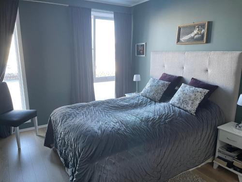 特罗姆瑟Ocean view apartment的一间卧室配有一张蓝色墙壁的床和一扇窗户