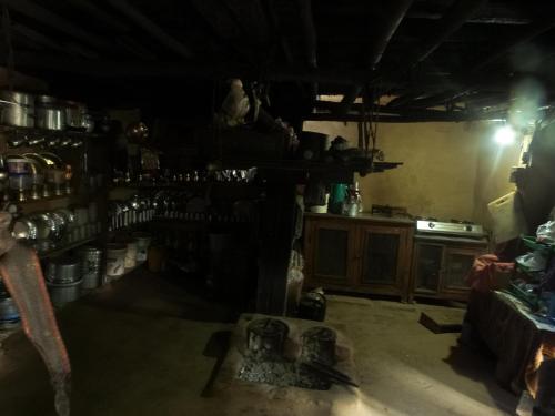 博卡拉Hemjakot Community Homestay的黑暗的客房设有1间带炉灶的厨房