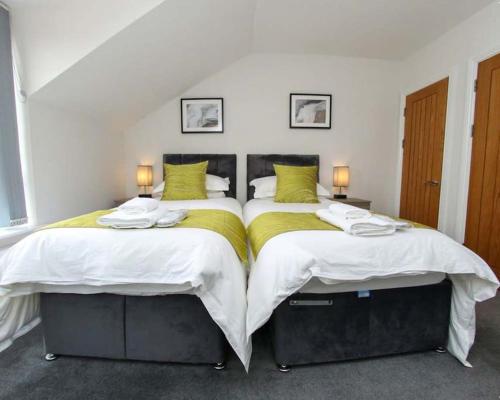 斯旺西Luxe Living Guest House-Sleeps 6-Private Parking-Free WIFI-Beach-City的卧室设有两张单人床和两盏灯。