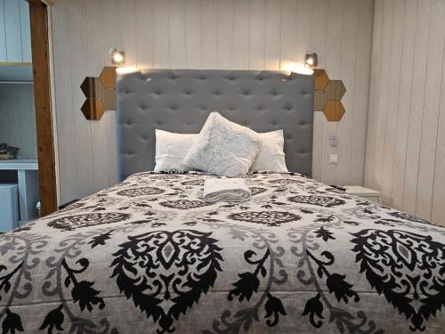 里斯本Charme da Graça的一间卧室配有一张带黑白色床罩的床。
