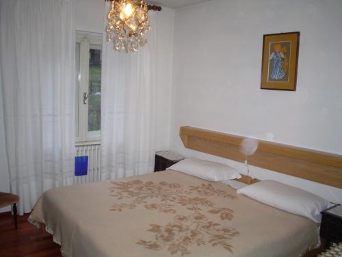 摩德纳迪-坎皮格里奥Campiglio Quadrilocale Castelletto Inferiore的一间卧室配有一张床和一个吊灯