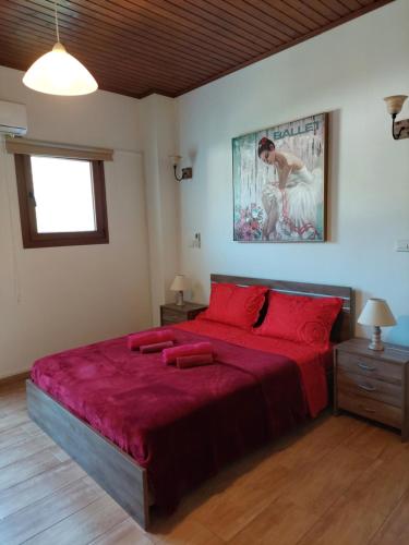 Tris EliesLove Holiday Suite 2的一间卧室配有一张带红色床单的大床