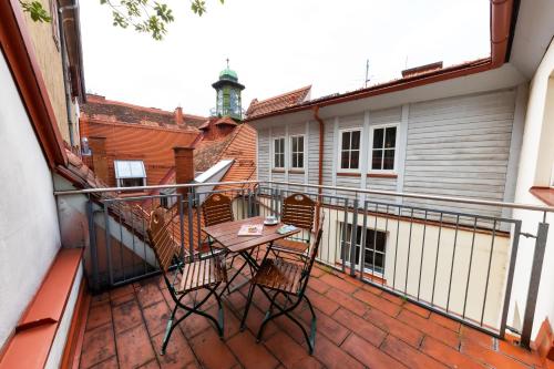 格拉茨Apartments am Glockenspielplatz的阳台的天井配有桌椅