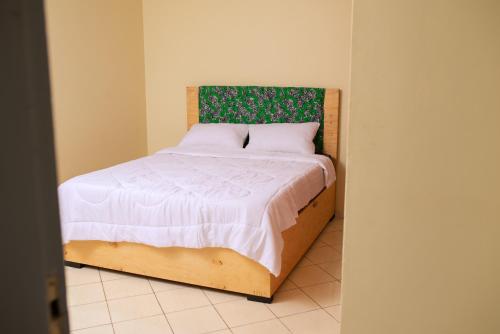 MunyonyoOlori Flats的一间卧室配有一张带绿色和白色棉被的床