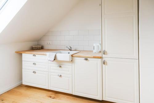 策勒Ferienwohnung Stylo 2.0的厨房配有白色橱柜和水槽