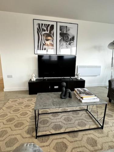 曼彻斯特Luxurious City View Apartment in Salford的客厅配有咖啡桌和电视
