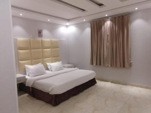 艾卜哈العرين بارك للشقق المخدومة的一间卧室设有一张大床和一个窗户。