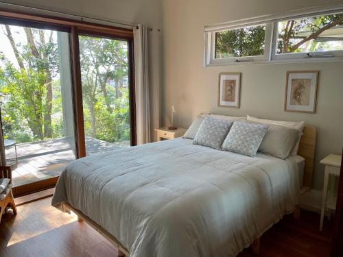 卧龙岗Tranquil Garden Studio的一间卧室设有一张床和一个大窗户