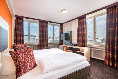 奥格斯堡Best Western Hotel Augusta的酒店客房设有一张床、一台电视和窗户。