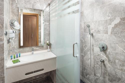 麦加Three Points Musalli Makkah的浴室配有盥洗盆和带镜子的淋浴