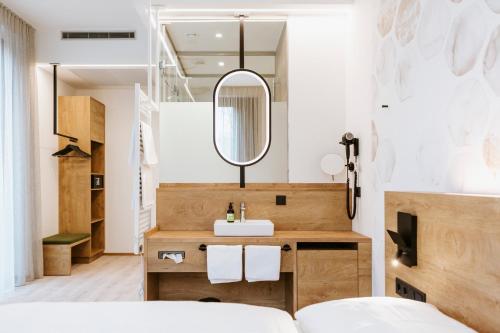 林茨BEE GREEN Linz Self-Check-in-Hotel的一间带水槽和镜子的浴室