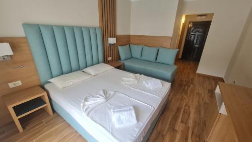 佩特罗瓦纳莫鲁Vile Oliva Hotel & Resort的一间卧室配有一张床和一张蓝色的沙发