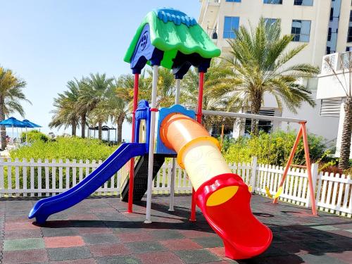 拉斯阿尔卡麦Luxurious Studio Pacific Al Marjan Island - beachfront property的一个带滑梯和滑梯的儿童游乐场