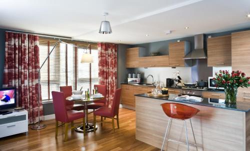 格拉斯哥格拉斯哥市中心梦幻公寓的厨房以及带桌椅的用餐室。