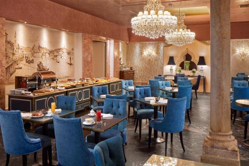 维罗纳学院酒店的一间配备有蓝色椅子和桌子的用餐室