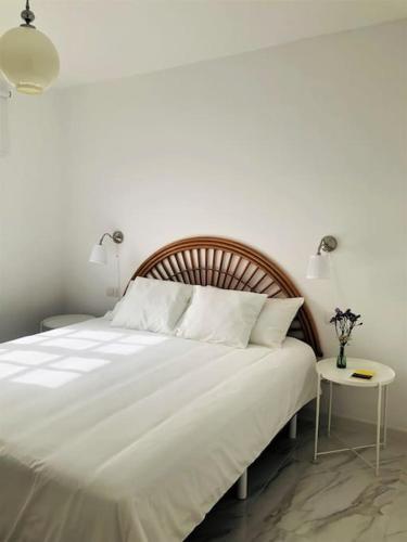 宏达海滩Casa Nicolás的卧室配有一张白色大床和一张边桌
