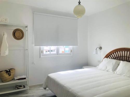 宏达海滩Casa Nicolás的白色的卧室设有床和窗户