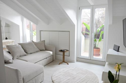 米兰La Maison City Life Apartments的白色的客厅配有沙发和窗户