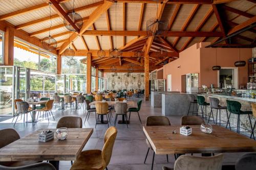 加沃拉诺Il Pelagone Hotel & Golf Resort Toscana的餐厅设有木制天花板和桌椅