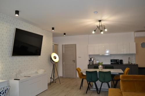 卡齐米日-多尔尼Villa Nova的客厅配有桌子和墙上的电视