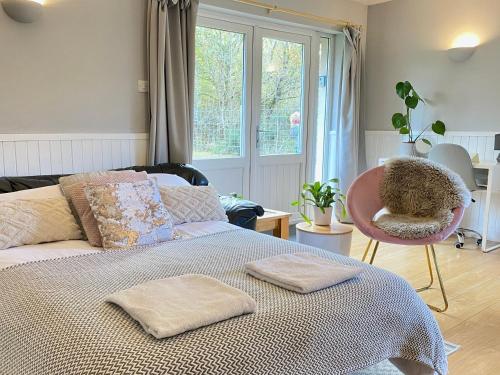 奥古斯都堡Homestead Cottage, Fort Augustus的一间卧室配有一张带椅子的床和一扇窗户