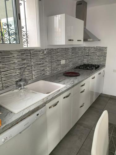 佩尼斯科拉Chalet Jamaica 2的白色的厨房设有水槽和炉灶。
