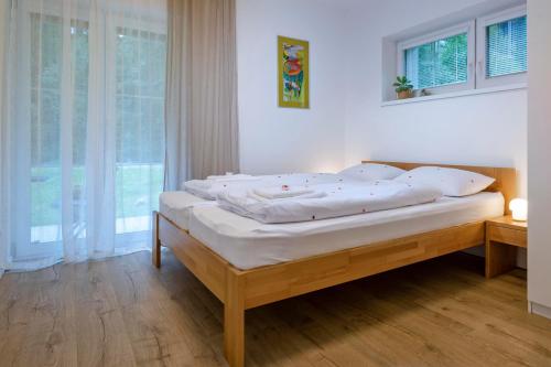 特尔乔夫Apartmán Vrátna的一间卧室配有一张带白色床单的床和一扇窗户。