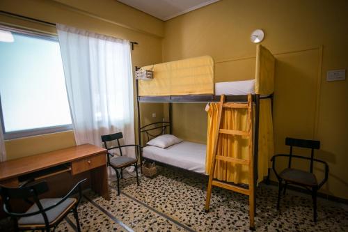 卡兰巴卡The Holy Rock - Hostel at meteora的客房设有两张双层床和一张桌子及椅子。