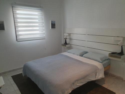 内坦亚CHAMBRE BLEUE 2 PERSONNES的白色的卧室设有床和窗户