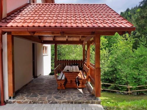 Ribnica na PohorjuApartma Ribnica na Pohorju的天井上带长凳的木制凉亭