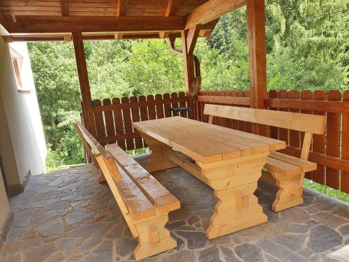Ribnica na PohorjuApartma Ribnica na Pohorju的天井上的木餐桌和长凳