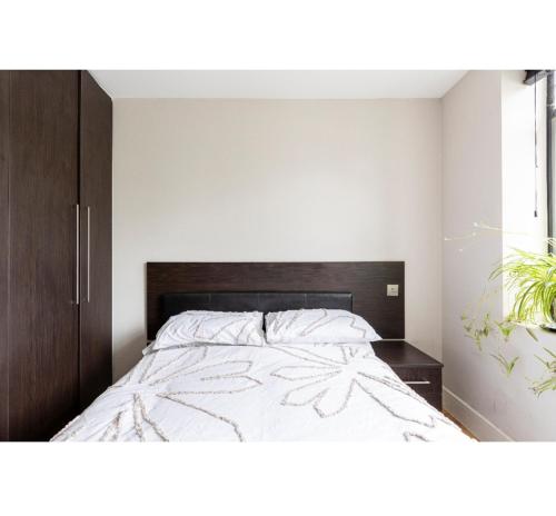 伦敦Bitcoin superior king room的一间卧室配有一张带木制床头板的床