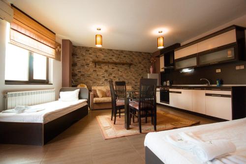 桑丹斯基SPA Apartments Perun的带两张床和一张桌子的房间以及一间厨房