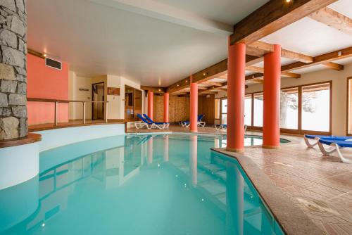 佩塞克鲁瓦拉格朗日拉罗拉瑞假日公寓式酒店的一座配有桌椅的酒店游泳池