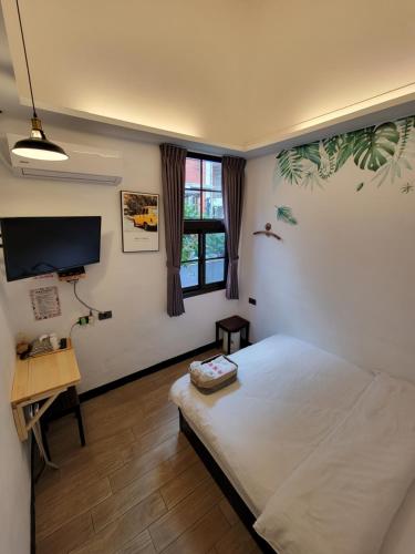 龙潭OLD WOW老屋瓦共享民宿Hostel 桃園市民宿074號的一间卧室配有一张床、一张书桌和一台电视
