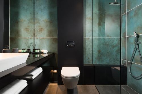 巴特亚姆master Bat Yam Aparthotel的带淋浴、卫生间和盥洗盆的浴室
