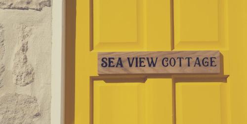 波特兰Sea View Cottage的黄色门,上面标有阅读海景小屋的标志