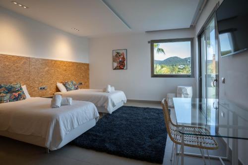Can FurnetEs Maiols Casa B的酒店客房,设有两张床和一张玻璃桌