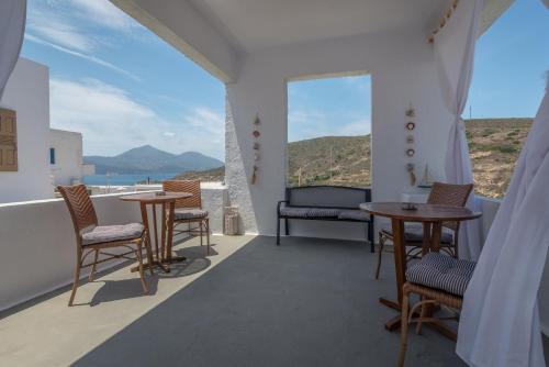 阿达玛斯moments rooms的阳台配有桌椅,享有海景。