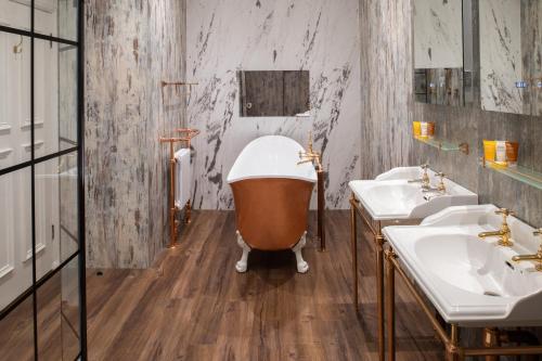 艾尔费尔菲尔德别墅酒店的浴室配有3个盥洗盆和浴缸。