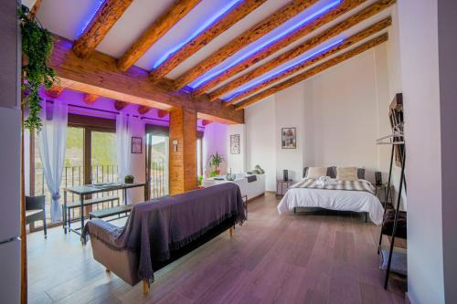阿尔卡拉德尔胡卡尔Apartamento Villar的一间卧室配有一张带紫色灯的天花板床。