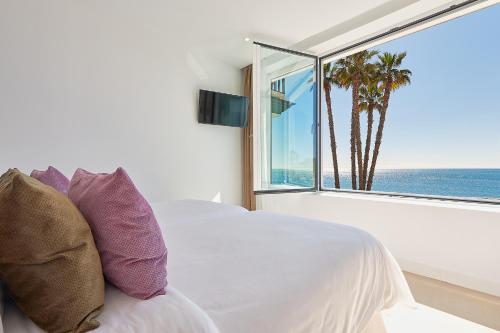 马拉加Suite Deluxe Face Mer Apart Malaga的一间卧室设有一张床,享有海景