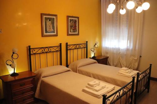 斯嘉德瓦利Casa nel Delta del Po的黄色墙壁客房的两张床