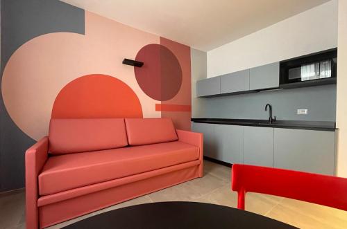 阿科Arqué Apartments - Arco Centro的一间带红色沙发的客厅和一间厨房