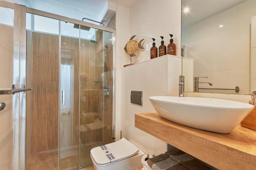 马拉加Suite Deluxe Face Mer Apart Malaga的一间带水槽、淋浴和卫生间的浴室