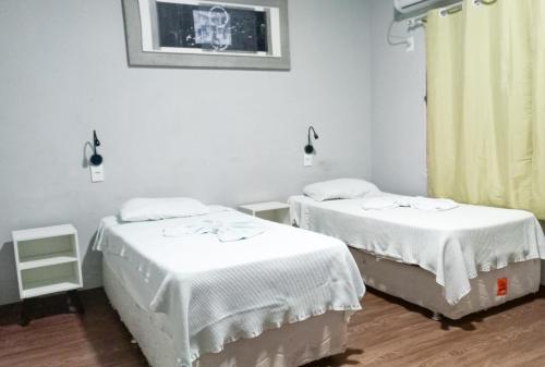 马瑙斯Mindú Park Hotel的医院房间设有两张床铺,配有白色床单