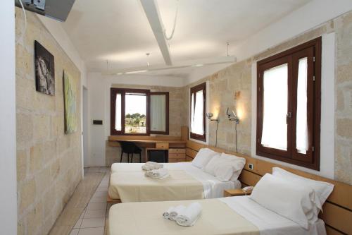 法维尼亚纳Hotel Delle Cave的酒店客房配有两张床和一张书桌