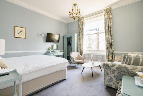 伦敦The Abbey Notting Hill的一间卧室设有一张床和一间客厅。