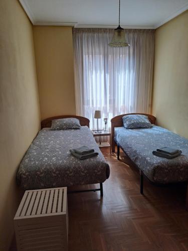 奥维多Los Prados - HUCA Oviedo - Parking gratuito的客房设有两张床和窗户。