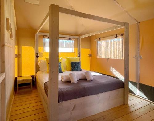 赞布热拉-杜马尔Kuanza Farmhouse and Lodge的一间卧室设有一张带黄色墙壁的天蓬床